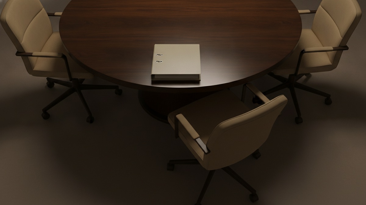 A conference room table photographed from above with three chairs pushed in and one pulled away, an unopened binder resting where the fourth chair would be